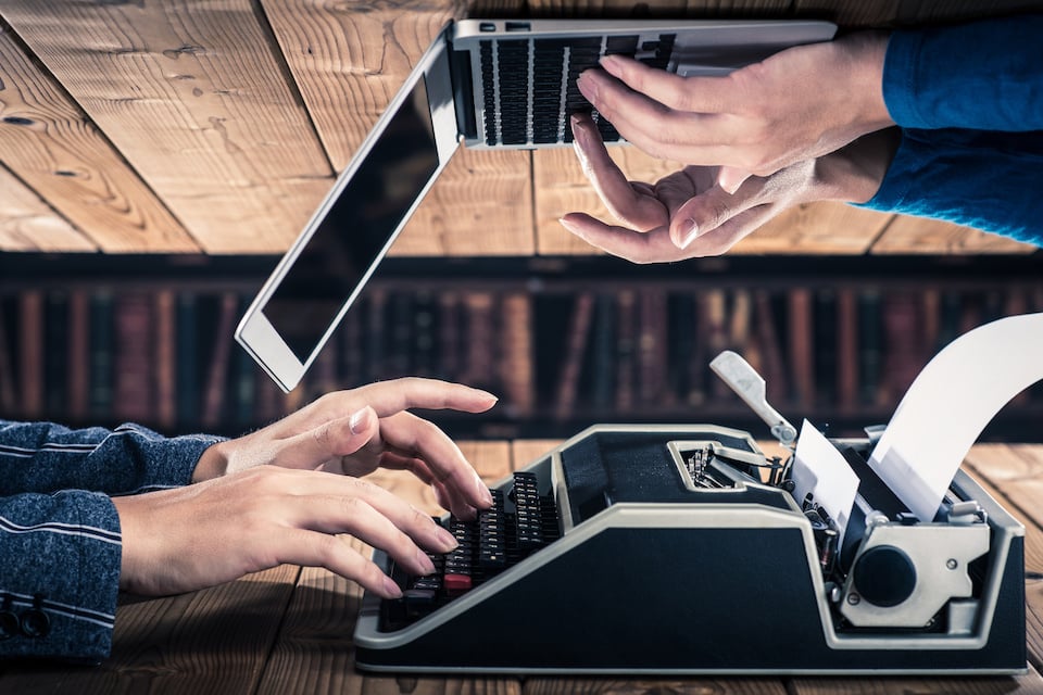 Article featured image showing hands typing on an old typewriter and on a modern laptop.